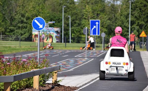 Children driving pedal cars in the children's traffic park