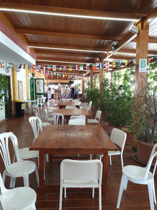 Kielikoulun terassi, jossa pöytä, jonka ympärillä valkoisia tuoleja. Tila koristeltu eri valtioiden lipuilla.