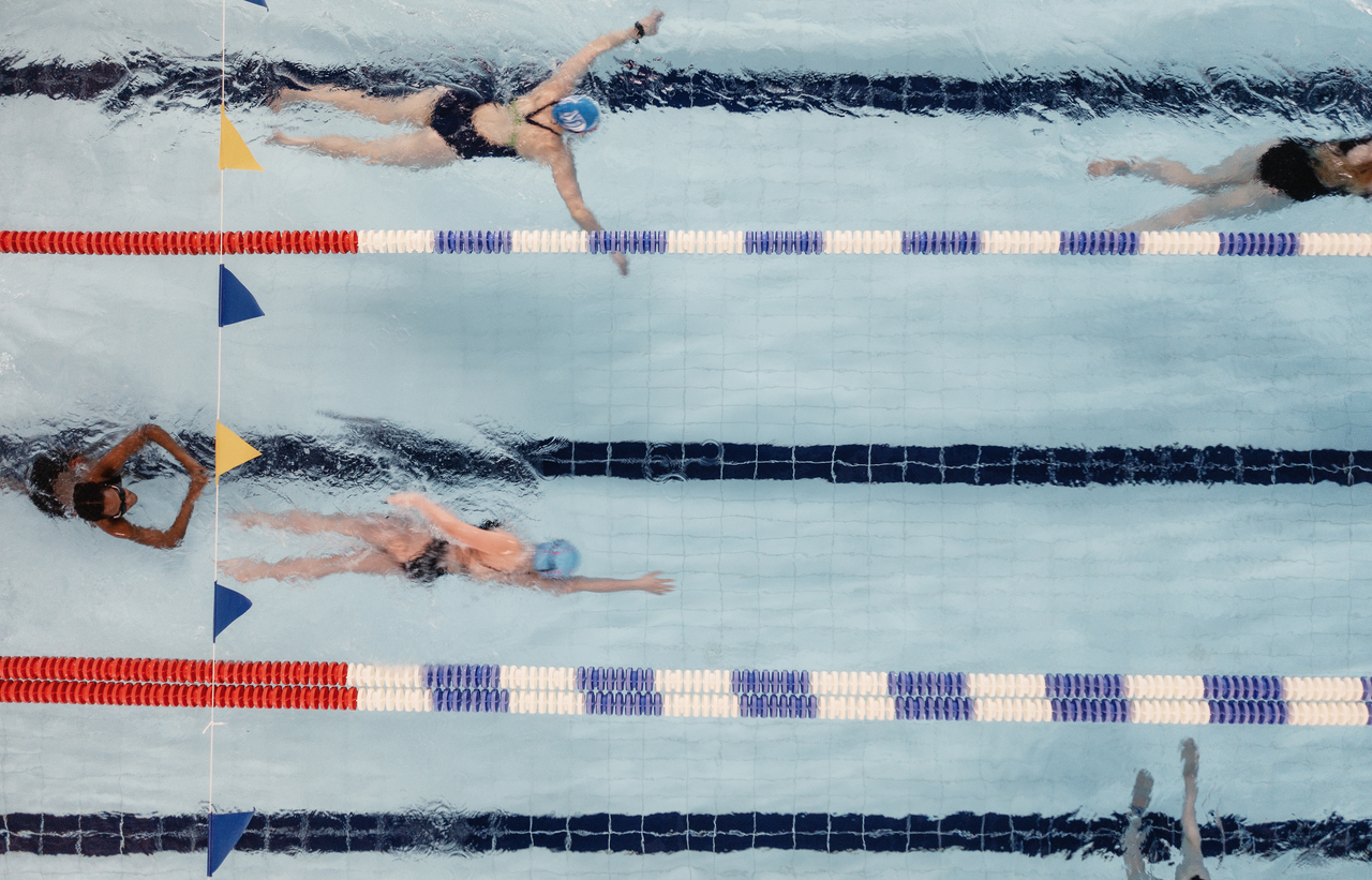 Uimareita uimahallissa ylhäältä kuvattuna.