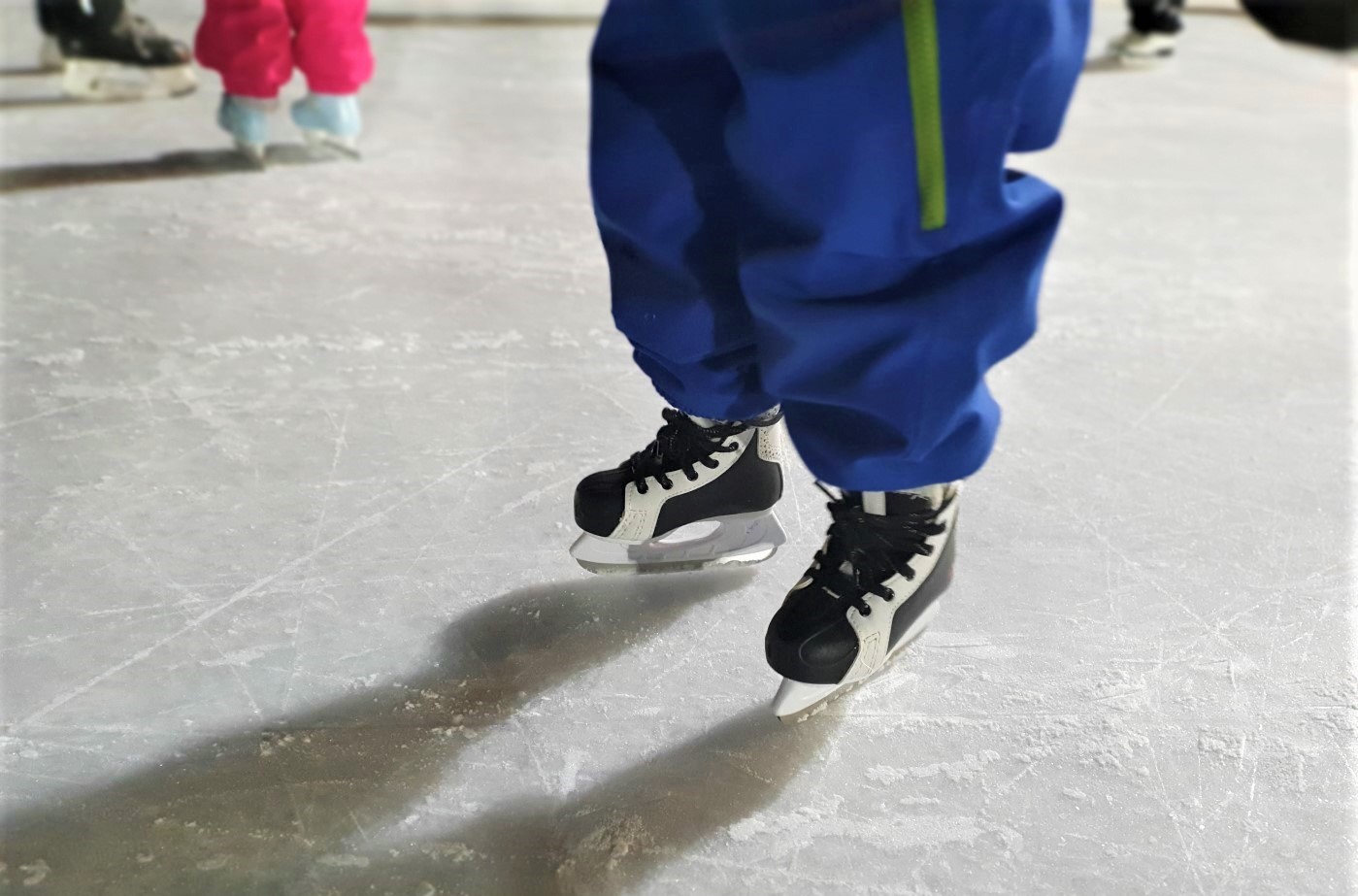 Pienen luistelijan luistimet ulkojäällä.