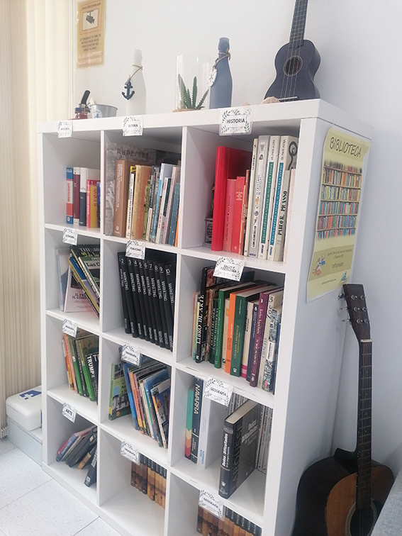 Valkoinen kirjahylly täynnä erilaisia kirjoja.