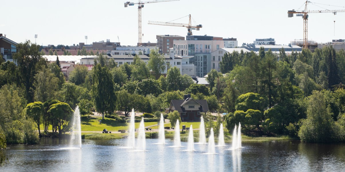 Vanha rakennus veden äärellä. Taustalla uudempaa kaupunkirakentamista.
