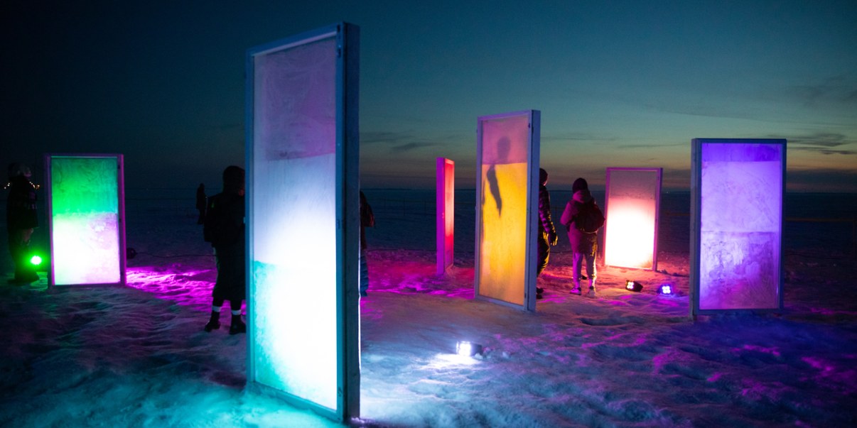 Valaistuja oven muotoisia kehikkoja jäällä.