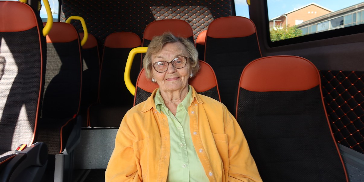 Asiakas istuu palveluliikenteen bussissa.