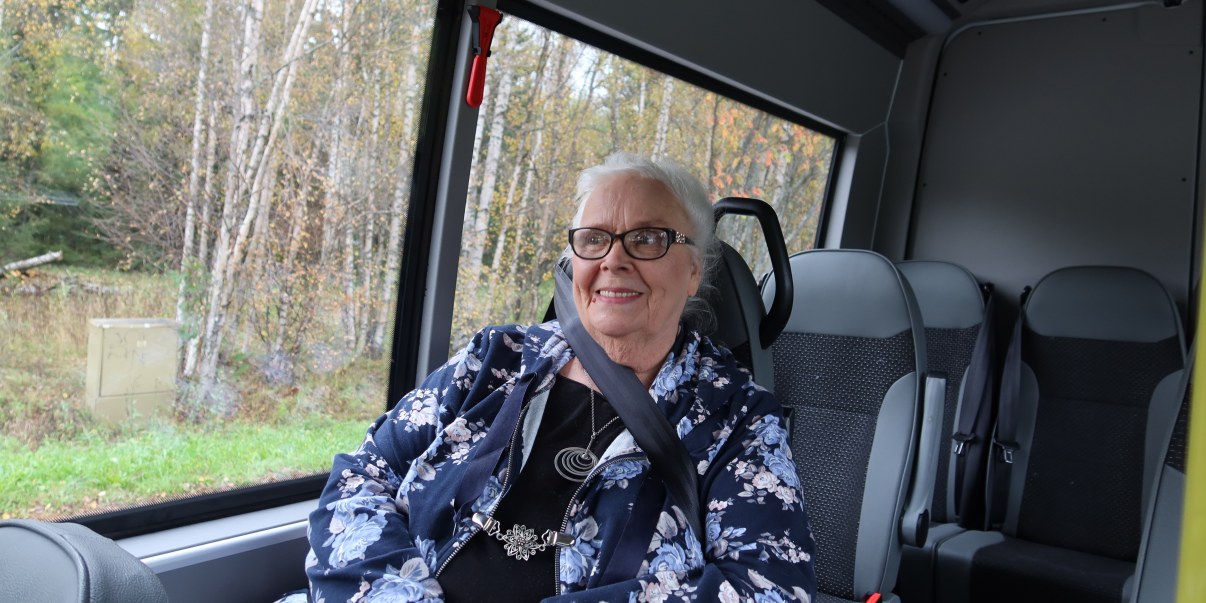 Asiakas istuu palveluliikenteen bussissa.