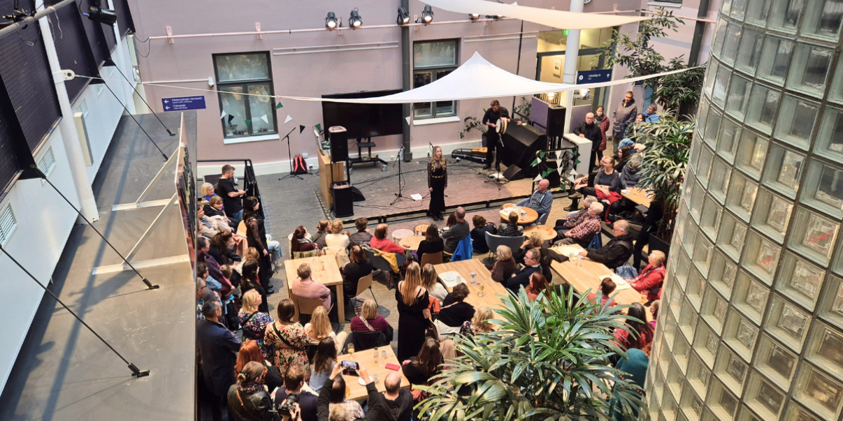 Ihmisiä seuraamassa esitystä kulttuuritalo Valveen kahvilassa.