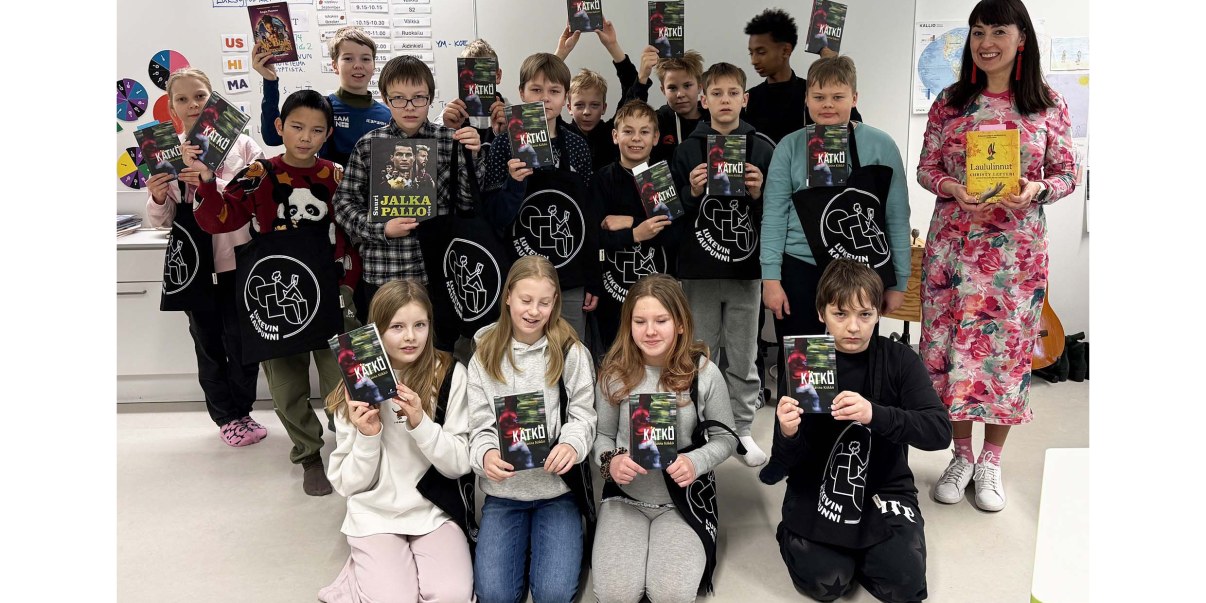 Koululuokka ja opettaja käsissään kirjoja.