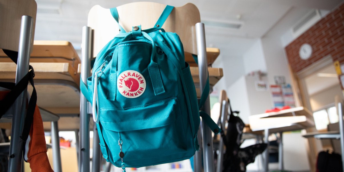 Kansikuva, reppu ripustettuna tuoliin