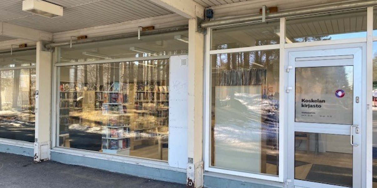 Lasiseinä, jossa ovi, ovessa teksti Koskelan kirjasto.