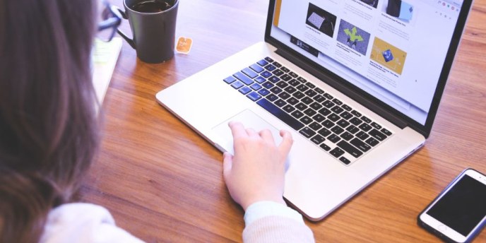 henkilö käyttää kannettavaa tietokonetta