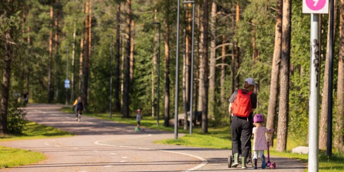 Pyöräbaana, lapsi ja vanhempi kävelee kuvan oikeassa laidassa kävelykaistalla.