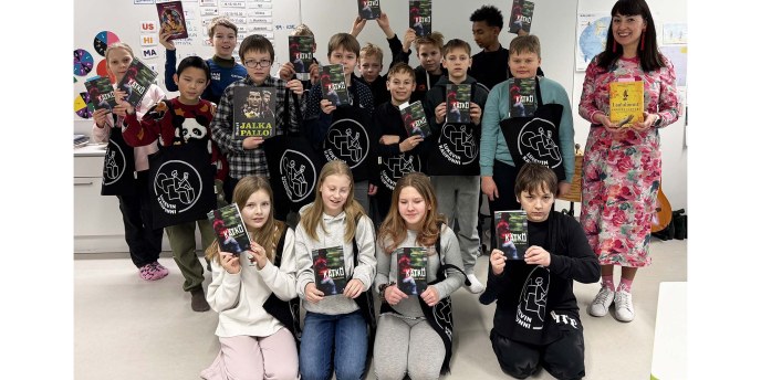 Koululuokka ja opettaja käsissään kirjoja.