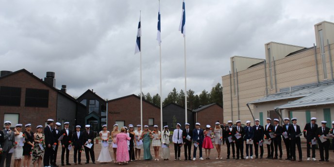 Ylioppilaat koulun pihalla