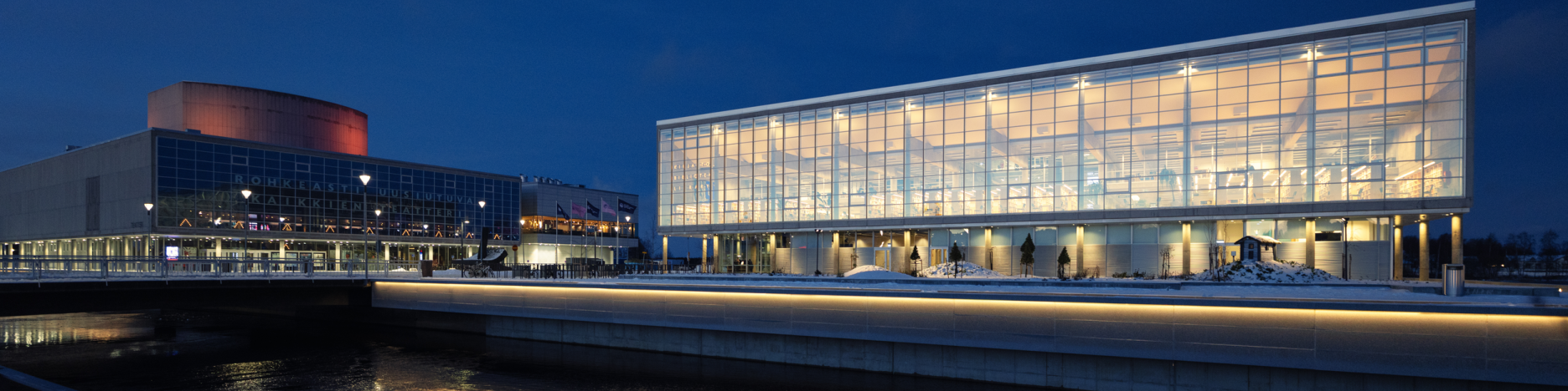 Öinen ilmakuva keskustakirjasto Saaresta, ikkunoista loistaa valo.
