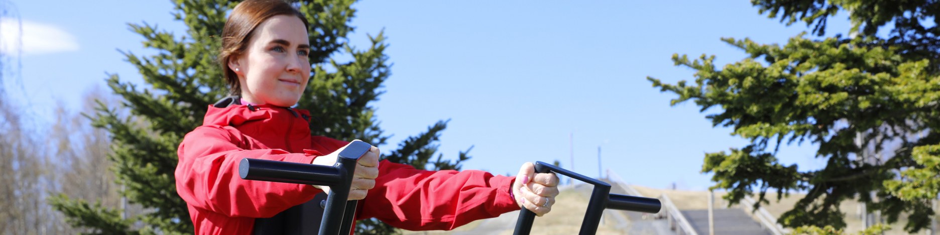 Nainen harjoittelee kevätsäässä ulkokuntosalilla