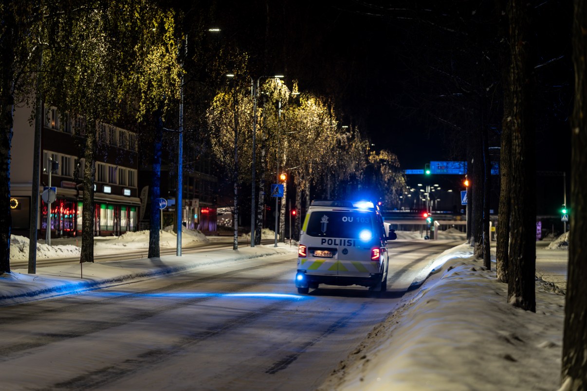 Poliisiauto ajaa hälytysajoa Saaristonkadulla. Katulamput valaisevat pimeää ja talvista katua..