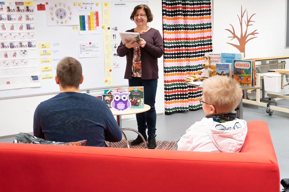 Kirjaston työntekijä vinkkaa kirjoja oppilaille luokassa.