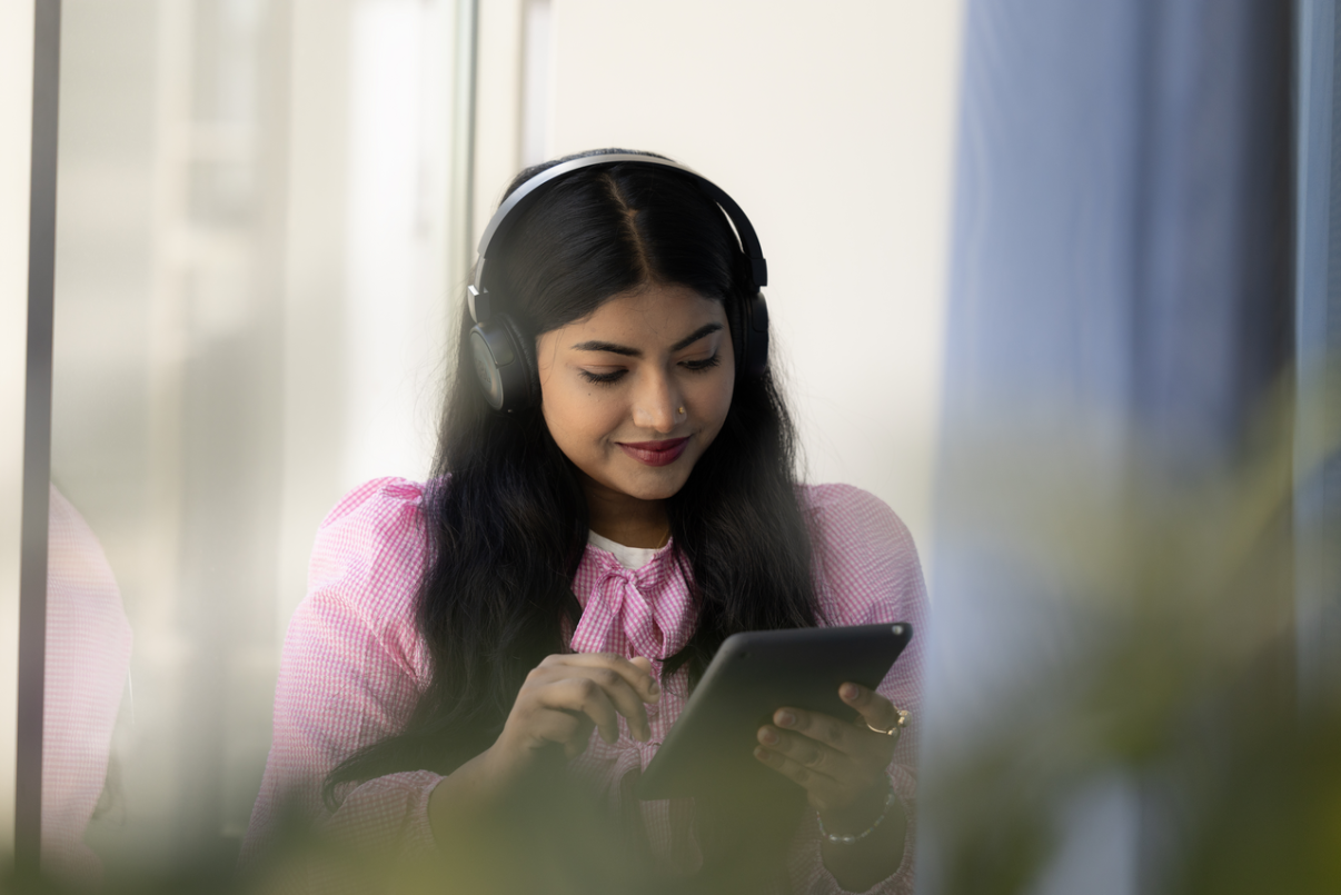 Nuori nainen kirjastossa käyttää tablettia