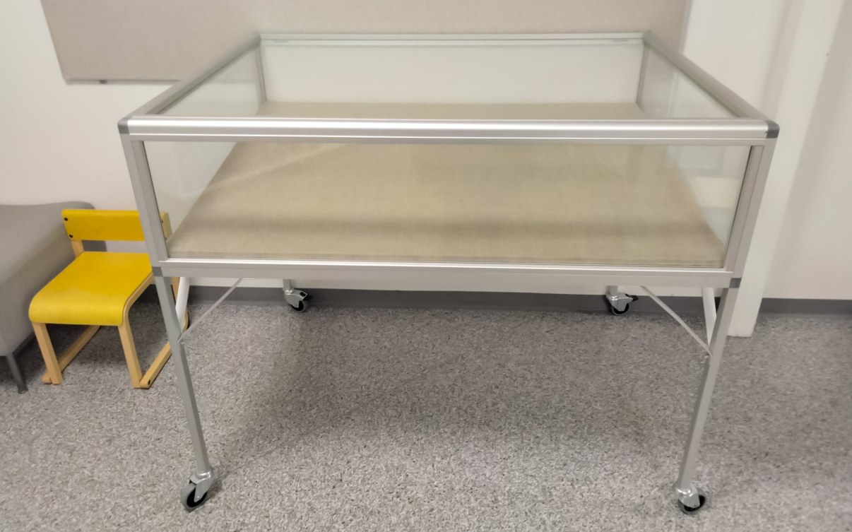 Matala näyttelyvitriini jalkojen päällä