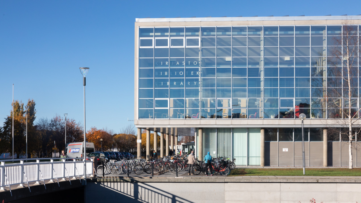 Lasia ja betonia oleva rakennus, jonka edustalla on pylväitä.