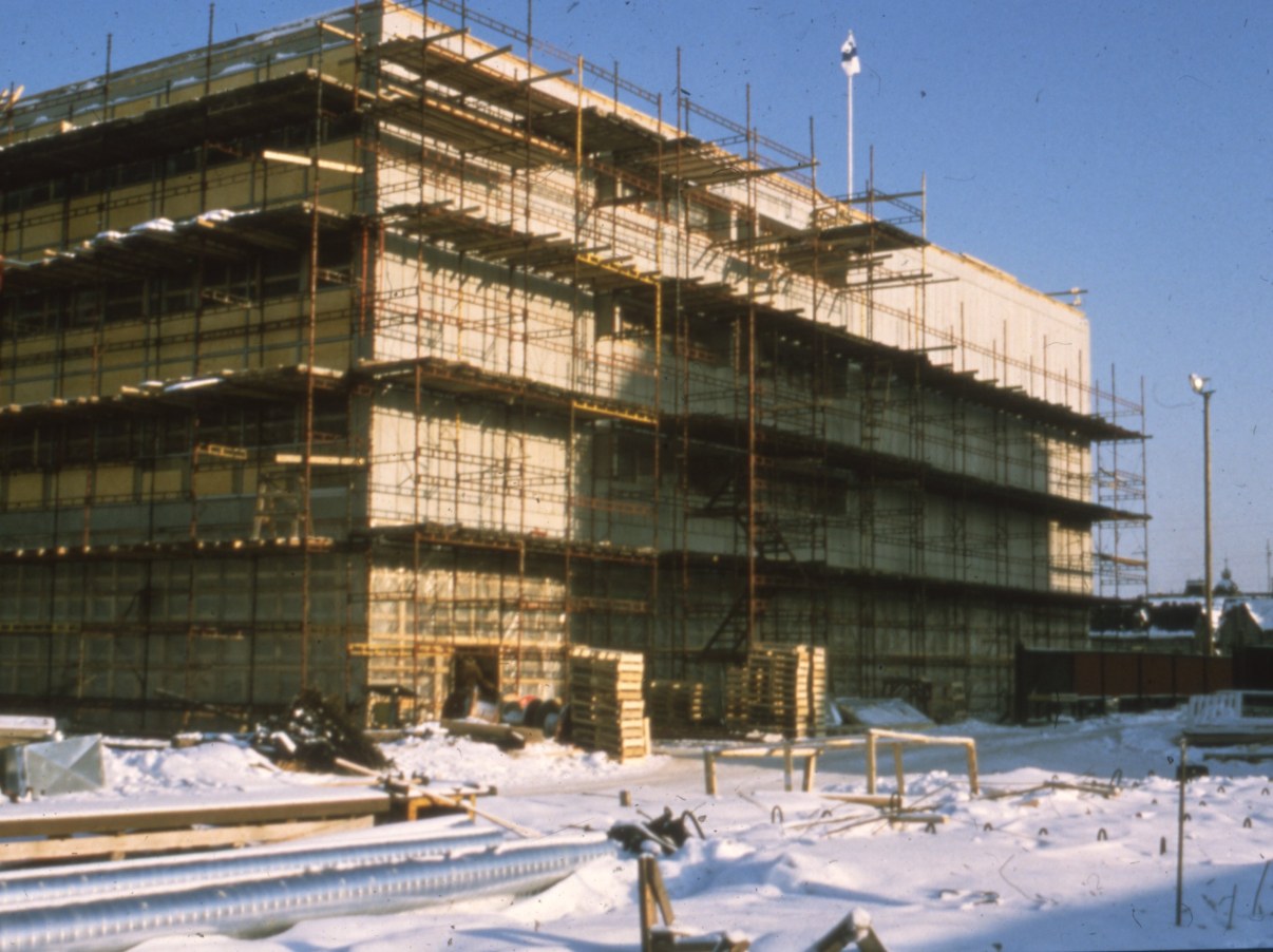 Rakennustelineiden ympäröimä, suuri rakennus.