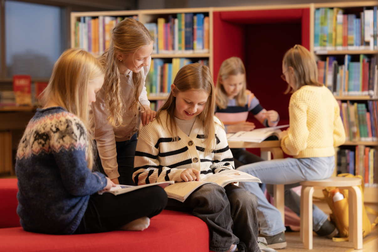 Koululaisia kirjastossa lukemassa kirjoja