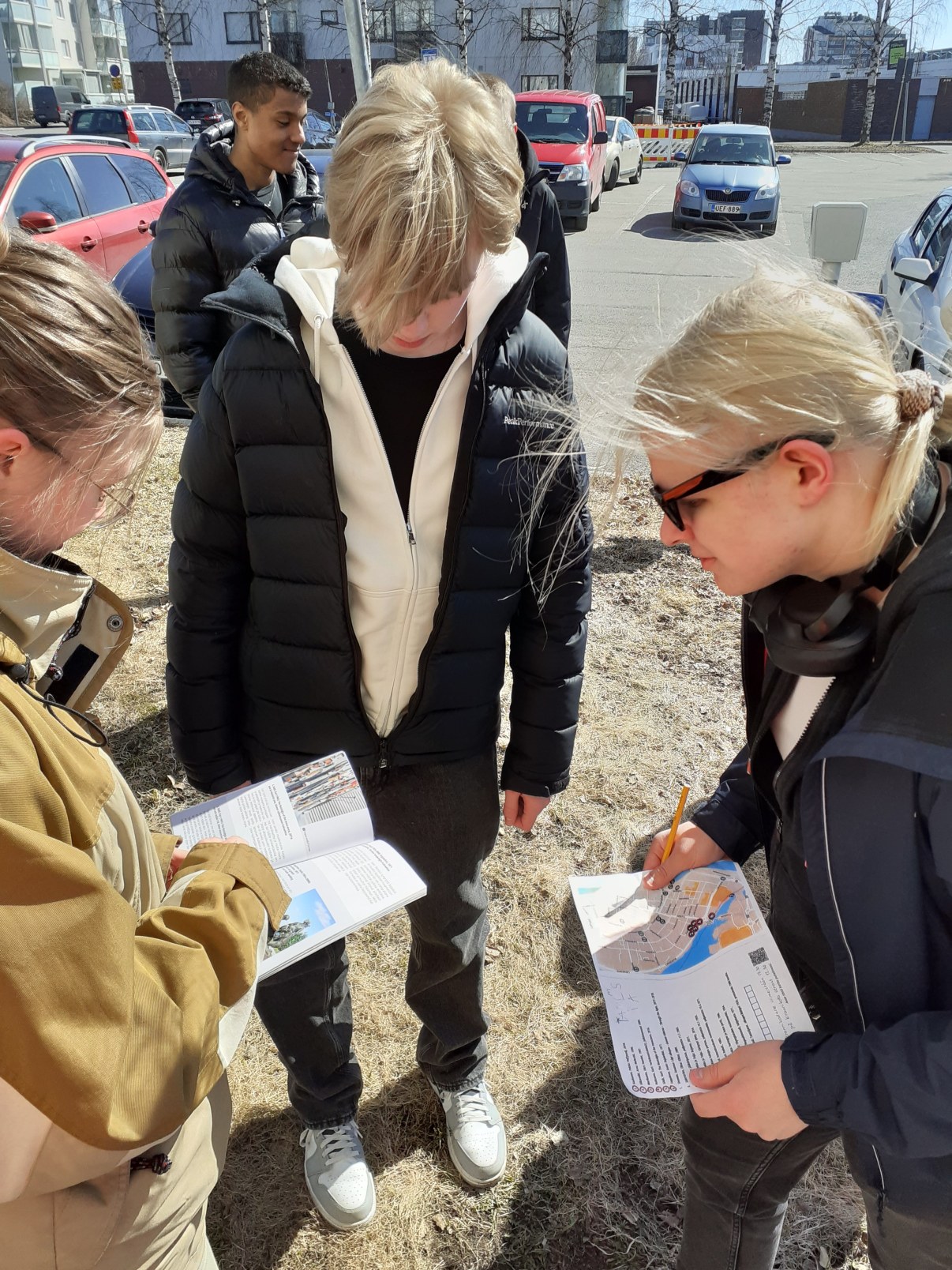 Opiskelijoita kulttuurikävelyllä tutkimassa paperikarttaa.