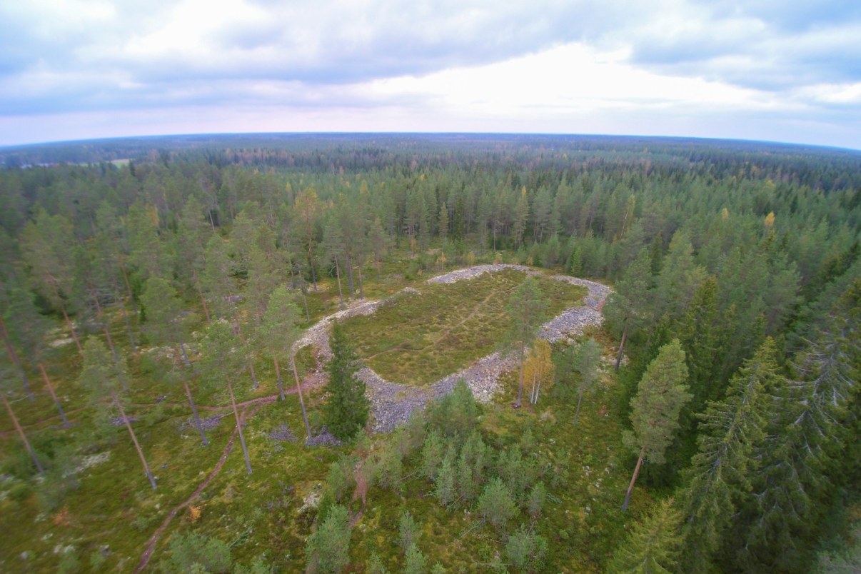 Ilmakuvassa metsän keskellä kivien muodostama rengasmainen kuvio.