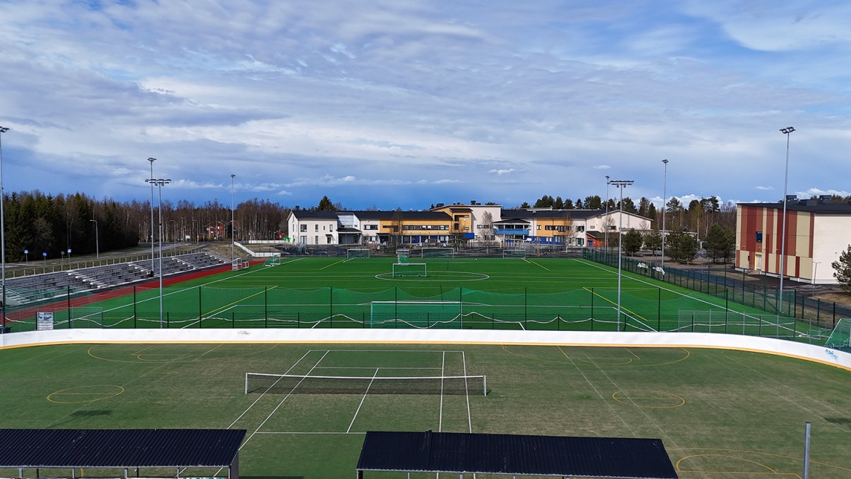 tenniskenttä ja jalkapallokenttä vierekkäin auringonpaisteessa.