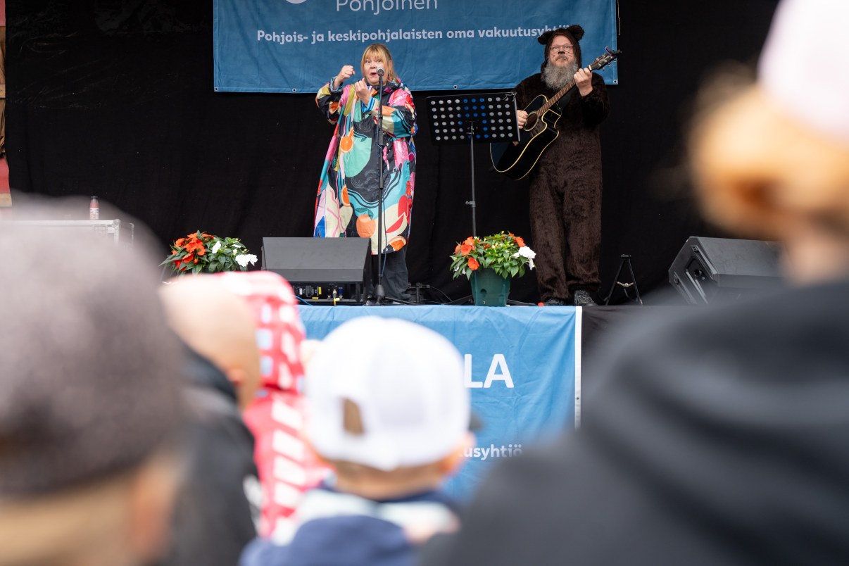 Laulaja ja kitaristi lavalla esiintymässä lapsiyleisölle. 