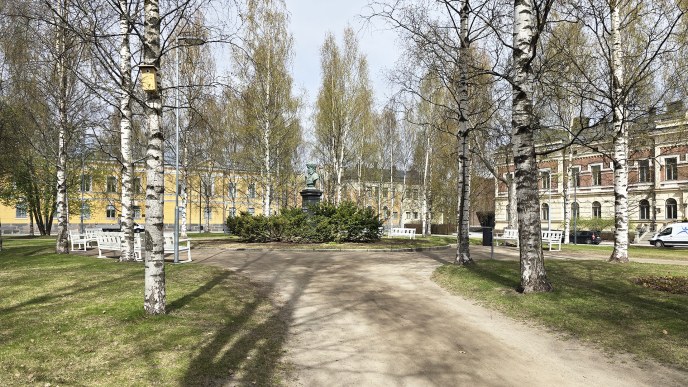 Kuvassa vihreä nurmialue, jonka keskellä on patsas.