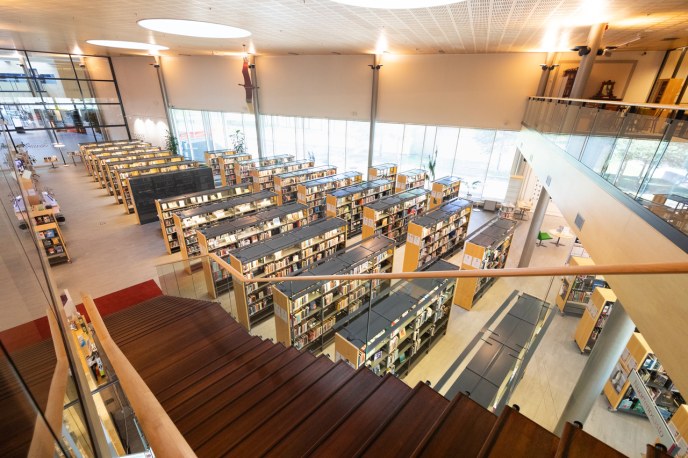 Näkymä Oulunsalon kirjastosta, portaikko ja kirjahyllyjä.