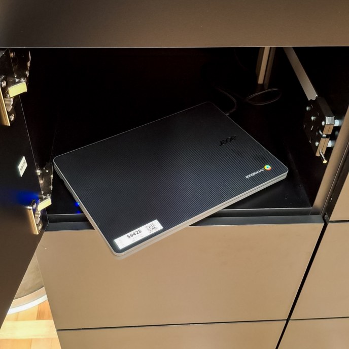 Kannettava tietokone avoimen kaapin hyllyllä.