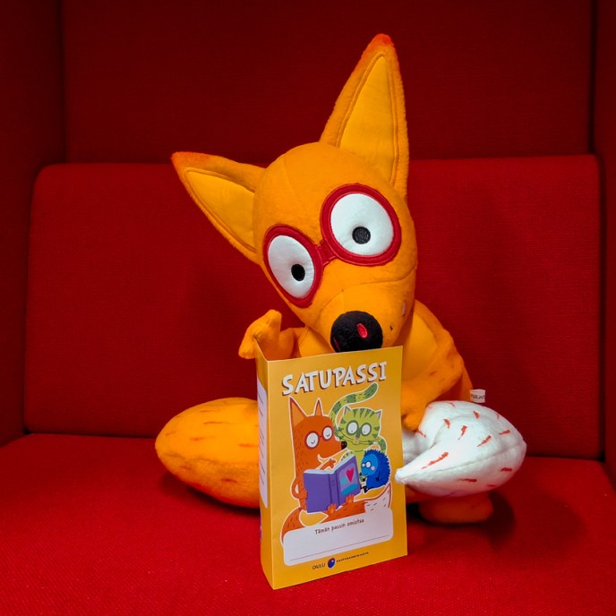 Pehmokettu istuu nojatuolissa edessään Satupassi.