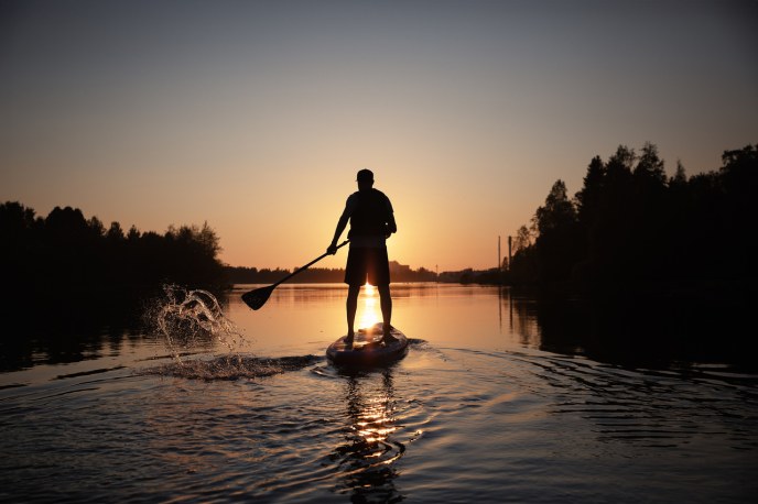 Sup-lautailija auringoslaskussa. 