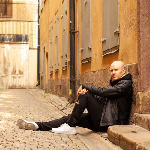 A man sitting on the ground leaning to a wall