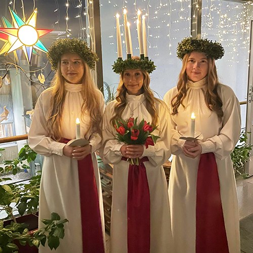 Kolme tyttöä Lucia-puvuissa